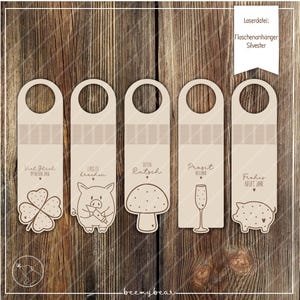 Op de afbeelding: Vijf houten flestags met feestelijke ontwerpen en tekst. Elke tag heeft een andere afbeelding: een klavertjevier, een varken, een paddenstoel, een champagneglas en nog een varken. De tags hebben een gat aan de bovenkant om op te hangen.