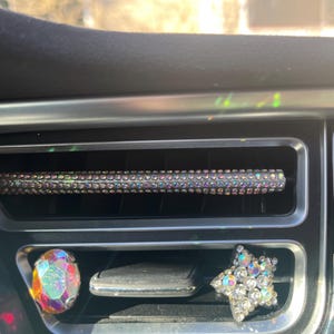 以下が含まれることがあります： 車のエアコン吹き出し口に、装飾用のアクセサリーが2つ付いています。1つは星型のクリアな虹色のクリスタルです。もう1つは涙型のクリアな虹色のクリスタルです。