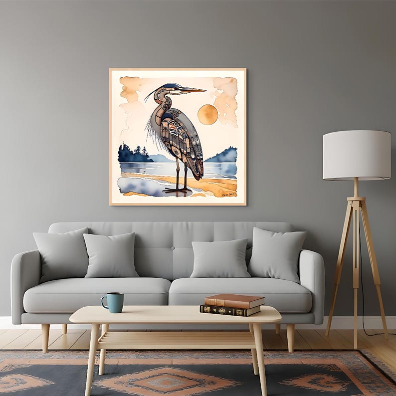 K&ouml;nnte beinhalten: Ein gerahmter Aquarelldruck eines Graureihers, der an einem Strand steht. Das Kunstwerk zeigt eine detaillierte Illustration des Vogels mit einem Sonnenuntergang und Wasser im Hintergrund. Der Reiher ist in Grau-, Blau- und Braunt&ouml;nen dargestellt.