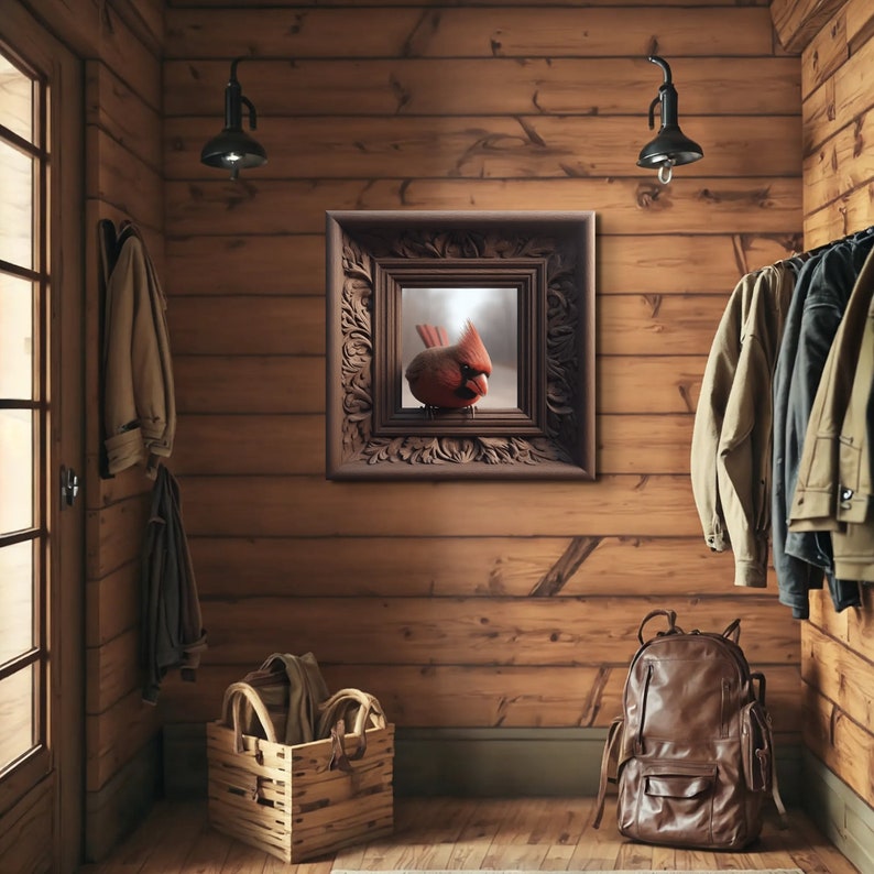 May include: A framed print of a red cardinal bird perched on a branch, with a blurred background of a snowy forest. The frame is ornate and dark brown, with intricate carvings. The print is hanging on a wooden wall in a rustic setting.
