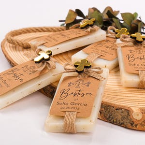 These beautiful handmade scented soap favors are a thoughtful gift for your special occasion. Ideal for baptisms, confirmations, christenings, first holy communions, quinceanera, sweet 16 or religious celebrations, each soap comes with a kraft paper tag customized with your guest of honor’s name, event date, and a personal message.

Each favor is topped with a rustic jute twine bow and a delicate charm, creating a charming and elegant presentation. Soaps are available in various scent-colors.