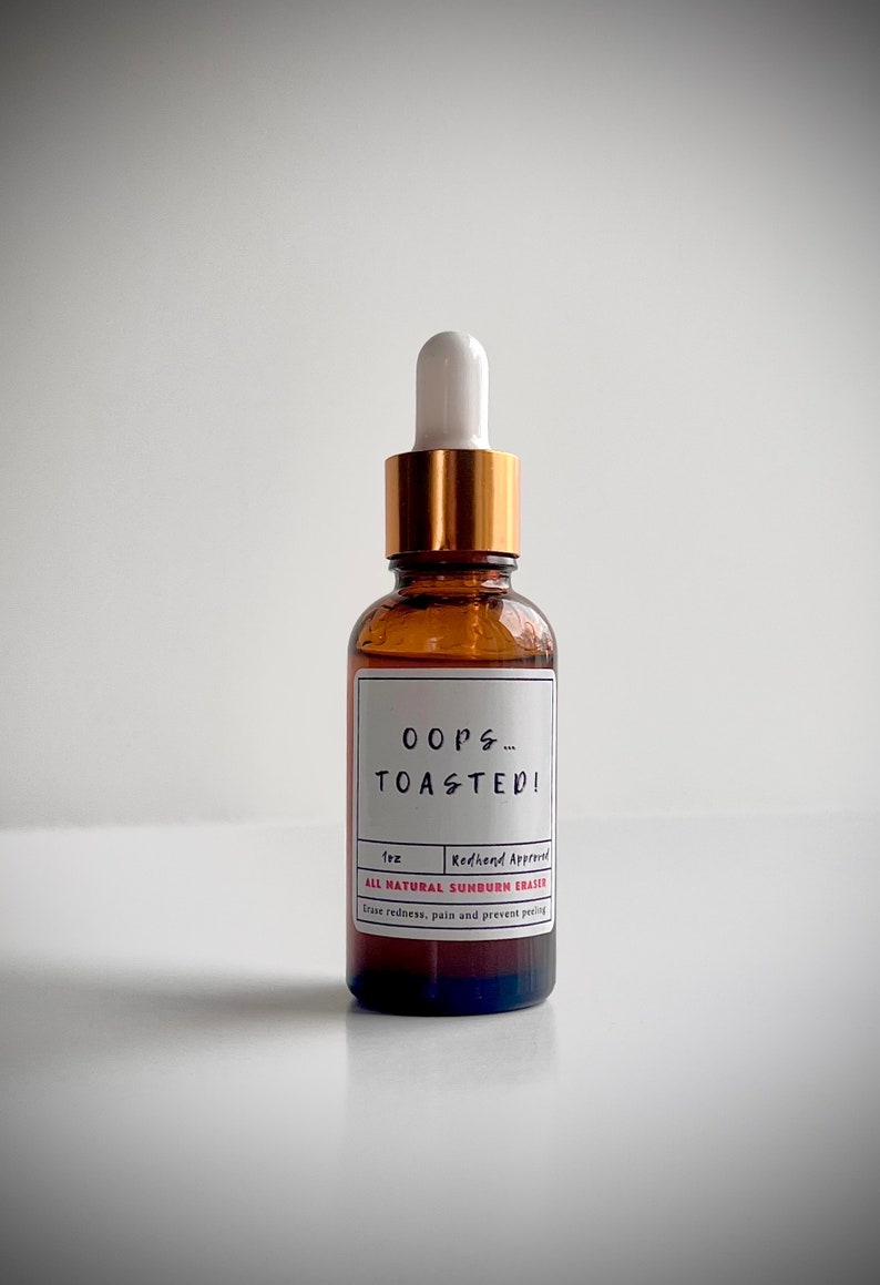 May include: A brown glass bottle with a gold cap and a white dropper. The label reads "OOPS... TOASTED!" and "ALL NATURAL SUNBURN ERASER".