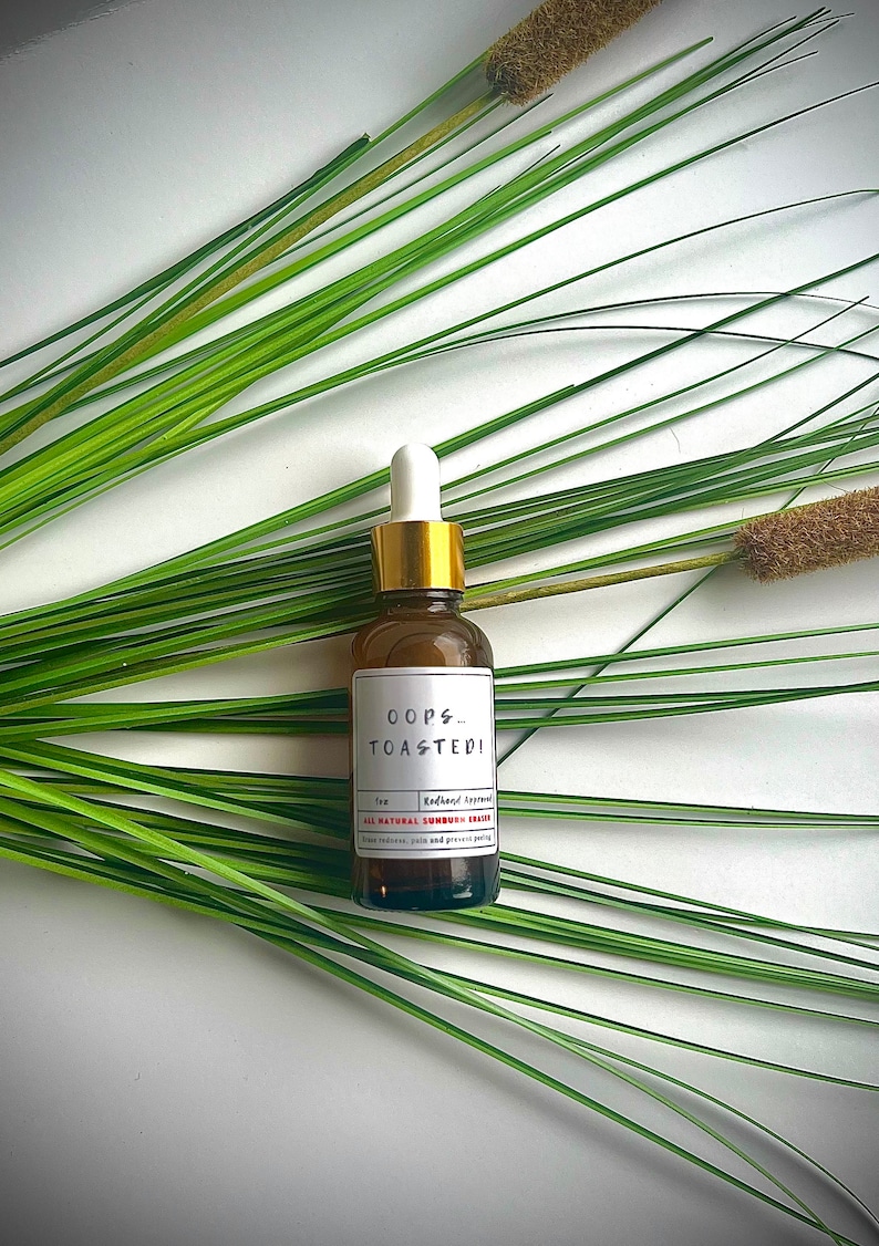 May include: A brown glass bottle with a gold cap and a white label that reads "OOPS...TOASTED!"  All Natural Sunburn Eraser.  Redhead Approved.