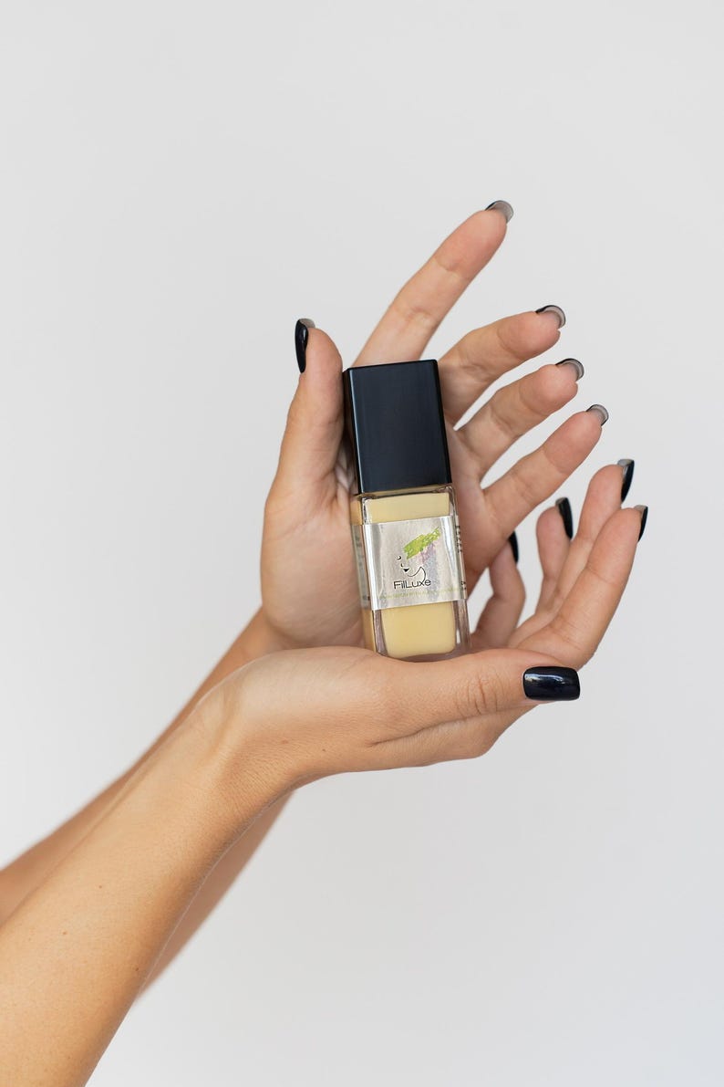 Hand holding vegan aloe vera serum bottle, clean skincare product.