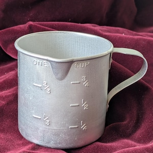 1 cup aluminum measuring cup with welded handle.