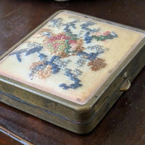 Compact de maquillage vintage avec de la poudre rose, un miroir et un compartiment.