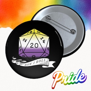 May include: A black button with a non-binary pride flag design. The design features a D20 die with the number 20 in the center, and the text "HOW I ROLL" on a banner. The word "Pride" is written in rainbow colors.