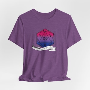 May include: Purple t-shirt with a graphic of a 20-sided die with a pink, blue, and purple color gradient. The die has the text "How I Roll" underneath it.