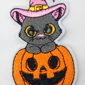 ハロウィン猫パッチ：ピンクの魔女の帽子をかぶった魔法の猫がカボチャの上に座っている（縫い付けまたはアイロン接着）アップリケ