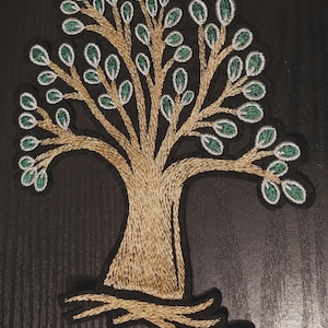 May include: A gold and green embroidered tree patch. The tree has a thick trunk and many branches with green leaves.