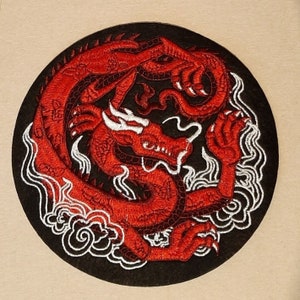 May include: A red embroidered dragon patch with white clouds on a black background.