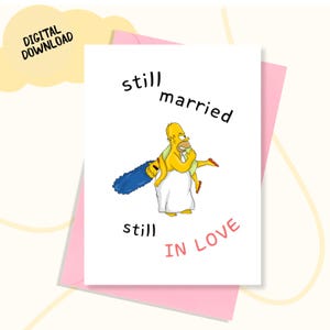 May include: A white greeting card with a pink envelope features a cartoon image of Homer Simpson carrying Marge Simpson. The card reads "still married, still in love" in black and red text. A yellow cloud with "DIGITAL DOWNLOAD" is in the upper left corner.