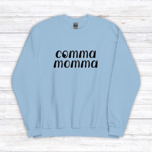 Peut inclure: Sweat-shirt bleu clair avec un texte noir qui dit "comma momma"