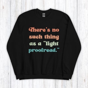 Peut inclure: Sweat-shirt noir avec une citation humoristique dans une police rétro : "Il n'y a pas de "lecture rapide"."