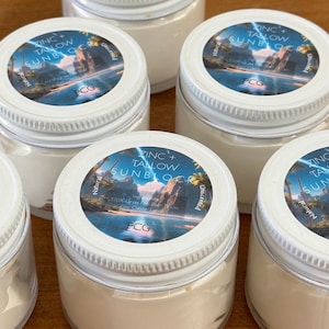 May include: Four white jars of zinc and tallow sunblock with blue and white labels. The labels have a tropical scene and the text "Zinc + Tallow Sunblock" and "PCG".