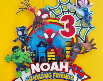 Op de afbeelding: Een kleurrijke taarttopper met Spider-Man-personages, waaronder Spider-Man, Spider-Gwen en Miles Morales. De topper bevat ook een nummer 3, de naam "Noah" en de tekst "en zijn geweldige vrienden".