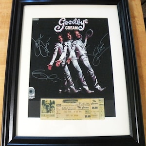 May include: A framed black and white photo of the band Cream, with their signatures, and a concert ticket for their farewell appearance at the Forum in Inglewood, California on October 18, 1968.