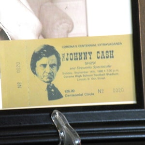 K&ouml;nnte beinhalten: Ein gelbes Ticket f&uuml;r die Johnny Cash Show and Fireworks Spectacular, die am 14. September 1980 im Corona High School Football Stadium in Corona, Kalifornien, stattfand. Das Ticket ist mit der Nummer 0020 versehen und kostet 25,00 $ f&uuml;r den Centennial Circle.