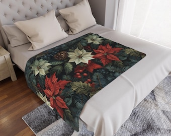 Könnte beinhalten: Eine dekorative Tagesdecke mit einem Poinsettia-Blumenmuster. Die Decke zeigt rote, weiße und grüne Poinsettien, Tannenzapfen und Beeren vor einem dunklen Hintergrund. Die Decke wird auf einem Bett mit weißer Bettwäsche präsentiert.