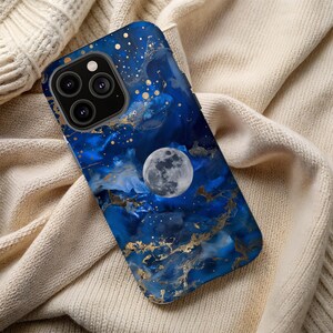 Könnte beinhalten: Eine blaue und goldene Handyhülle mit Marmormuster und einem Vollmond-Design. Die Hülle hat einen Ausschnitt für die Kamera.