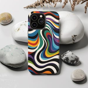 Puede incluir: Una funda de teléfono colorida con un patrón abstracto en espiral en tonos de azul, verde, amarillo, rojo y morado. La funda tiene un fondo negro y un contorno blanco.
