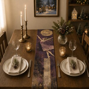 Peut inclure: Un long chemin de table rectangulaire orné d'une impression artistique violet foncé et dorée représentant une ballerine sautant vers une pleine lune. Il est disposé sur une table en bois avec des assiettes, des serviettes et des bougies.