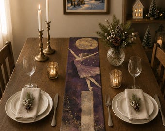 May include: A long rectangular table runner featuring a dark purple and gold artistic print of a ballerina leaping toward a full moon. The runner is centered on a wooden dining table set with white plates, linen napkins, candles, and glassware.