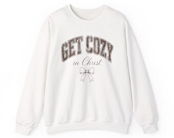 May include: A white crewneck sweatshirt featuring the text GET COZY in a dark brown collegiate font, with the words in Christ written below in a cursive script, and a simple line drawing of a bow centered at the bottom.