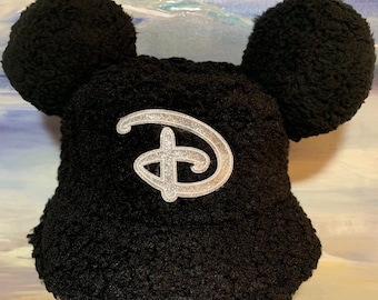 Black on Black! Black Sherpa Bucket Hat with Black Soft Sherpa Mickey Ears with a classic sparkling silver Disney D front and center!