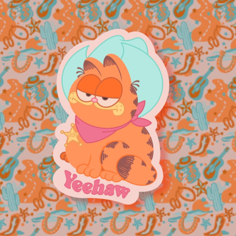 May include: A cartoon orange cat wearing a pink bandana and a light blue cowboy hat with the word "Yeehaw" written in pink below it. The cat is sitting on a pink background with a western-themed pattern.
