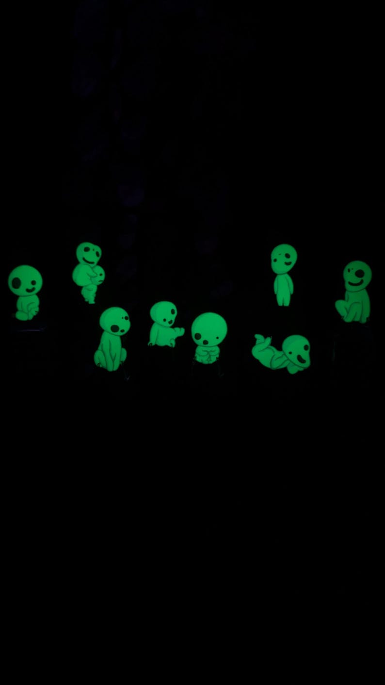 May include: A set of nine glow-in-the-dark green figures, each with a unique pose and expression. The figures are small and appear to be made of a soft material.