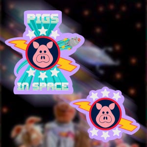May include: Two stickers with a cartoon pig face in a navy blue circle, surrounded by white stars and a yellow lightning bolt. The stickers have the text "PIGS IN SPACE" in a retro font, with a space-themed background.