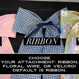 K&ouml;nnte beinhalten: Drei Stoffschleifen in rosa Vichy, blauem Vichy und floralen Mustern. Der Text auf dem Bild lautet "WIRE", "RIBBON" und "VELCRO", mit einer Beschreibung der Befestigungsoptionen: Band, Blumendraht oder Klettverschluss.