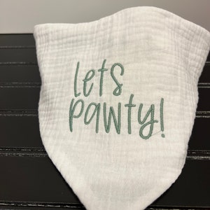 Pu&ograve; includere: Bandana di cotone bianco con ricamo verde che dice "Let's Pawty!"