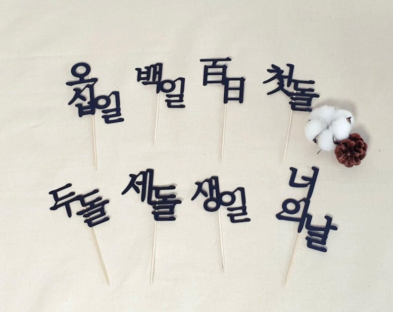 May include: Black and white Korean language word cutouts on sticks. The words are "오늘", "별", "꿈", "첫돌", "세돌", "생일", "너", "두돌".