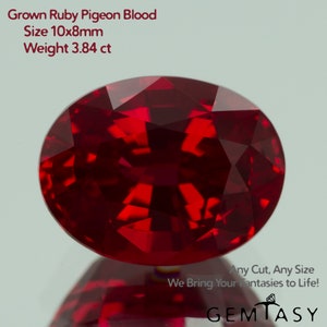 Può includere: Una gemma di rubino sfaccettata, taglio ovale, di colore rosso intenso. Il testo indica che si tratta di un Grown Ruby Pigeon Blood, di dimensioni 10x8mm e peso 3,84 ct. L'immagine include anche il testo "Any Cut, Any Size, We Bring Your Fantasies to Life!"