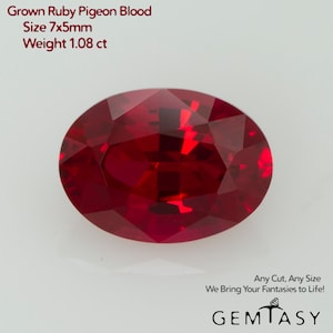 Op de afbeelding: Een ovaal geslepen, dieprode robijn edelsteen. De afbeelding bevat de tekst "Grown Ruby Pigeon Blood, Maat 7x5mm, Gewicht 1.08 ct." Extra tekst onderaan luidt "Any Cut, Any Size, We Bring Your Fantasies to Life!" en de merknaam "GEMTASY."