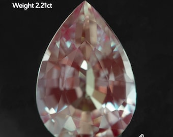 May include: A lab-grown alexandrite gemstone with a pear shape. The gem is a mix of pink and green hues, with a size of 10.5x7mm and a weight of 2.21ct. The image includes the text "Alexandrite lab-grown Size 10.5x7mm Weight 2.21ct".