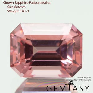 May include: A rectangular emerald-cut lab-grown Padparadscha sapphire with a pink-orange hue. Text reads: Grown Sapphire Padparadscha, Size 8x6mm, Weight 2.43 ct, Any Cut, Any Size We Bring Your Fantasies to Life!, and GEMTASY with a diamond icon.