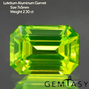 以下が含まれることがあります： ルテチウムアルミニウムガーネットと呼ばれる、鮮やかな緑色の長方形カットの宝石。宝石のサイズは7x5mmで、重量は2.30カラットです。