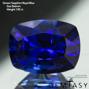 Może przedstawiać: Wyhodowany szafir w kolorze królewskiego błękitu o szlifie poduszkowym z fasetowaną powierzchnią. Tekst na obrazie brzmi: Grown Sapphire Royal Blue, Size 8x6mm, Weight 1.90 ct, Any Cut, Any Size We Bring Your Fantasies to Life!, GEMTASY.