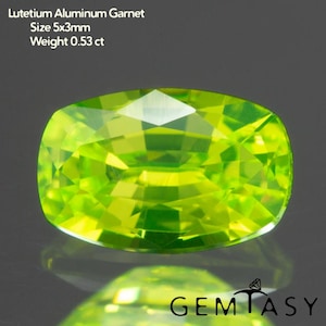 May include: A bright, lime green Lutetium Aluminum Garnet gemstone with a cushion cut. The gem measures 5x3mm and weighs 0.53 ct. The image includes the text "Lutetium Aluminum Garnet Size 5x3mm Weight 0.53 ct" and the Gemtasy logo.