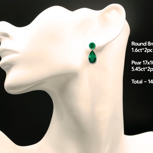 May include: A pair of emerald green earrings with a teardrop and round shape. The earrings are 1.6 carats and 5.45 carats, totaling 14.1 carats.
