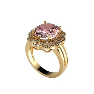 Può includere: Anello d'oro con una grande gemma rosa ovale, circondata da un alone di pietre più piccole e scintillanti. L'anello ha una fascia a gambo diviso. Il design è elegante e accattivante.