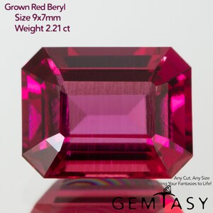 Könnte beinhalten: Ein lebendiger, rechteckig geschliffener roter Beryll-Edelstein. Der Edelstein ist 9x7mm groß und wiegt 2,21 ct. Das Bild enthält den Text "Grown Red Beryl" und "GEMTASY". Der Edelstein hat eine tiefe, gesättigte rote Farbe.