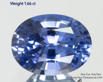 May include: A cornflower blue, oval-cut sapphire gemstone. The gem is 8x6mm in size and weighs 1.66 ct. Text on the image reads "Grown Sapphire Cornflower", "Any Cut, Any Size", and "We Bring Your Fantasies to Life!" The logo for GEMTASY is at the bottom.