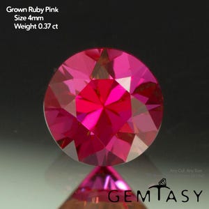 Può includere: Un rubino sfaccettato a taglio rotondo. La gemma è di un vibrante colore rosa, con una dimensione di 4 mm e un peso di 0,37 ct. Il testo "Grown Ruby Pink" e "GEMTASY" sono visibili.