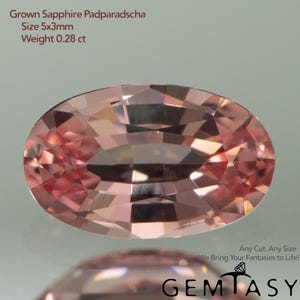 Può includere: Una gemma di zaffiro Padparadscha coltivato, rosa-arancio, taglio ovale e sfaccettato. La gemma misura 5x3mm e pesa 0,28 ct. Il testo "Any Cut, Any Size" e "We Bring Your Fantasies to Life!" con il logo Gemtasy.