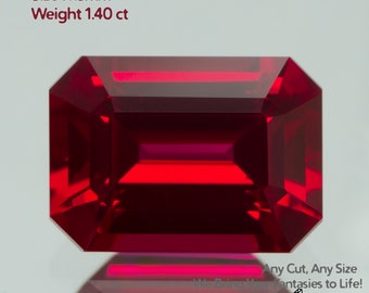 May include: A vibrant, rectangular-cut ruby gemstone with a deep red hue. The gem is labeled "Grown Ruby Pigeon Blood," with dimensions of 7x5mm and a weight of 1.40 ct. The image also includes the text "Any Cut, Any Size" and "We Bring Your Fantasies to Life!"