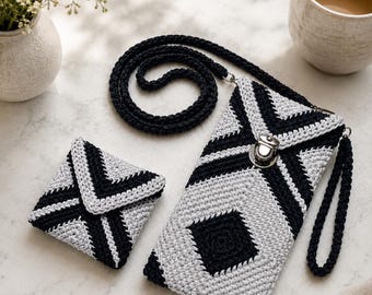 May include: A black and light gray crocheted phone pouch with a long strap and a matching square coin purse. The phone pouch features a silver metal clasp closure and a wrist strap, both items display a geometric pattern of black and gray yarn.